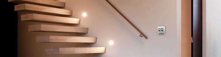 Das Bild zeigt eine Holztreppe mit sensorgesteuerter Beleuchtung.